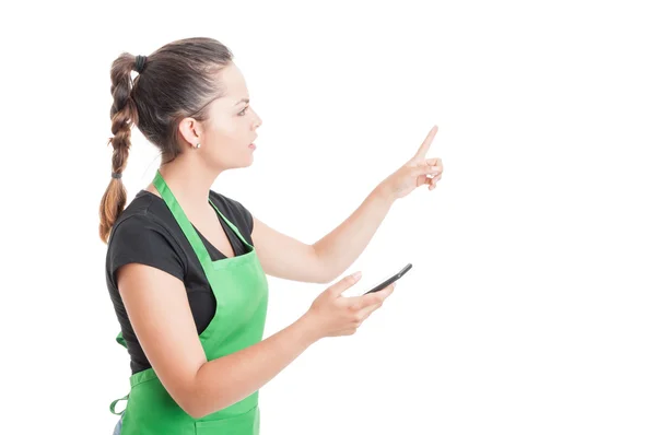 Young hypermarket employee with cellpone pointing at something — Stock Photo, Image