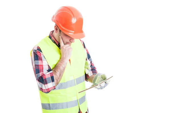 Constructor met moderne tablet denken aan iets — Stockfoto