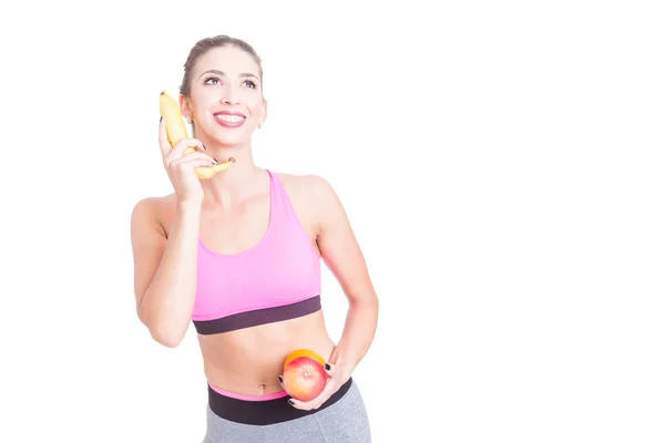 Donna in forma facendo gesto telefonico con una banana — Foto Stock