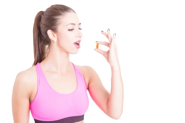 Jeune femme portant des vêtements de sport prenant la pilule minceur — Photo