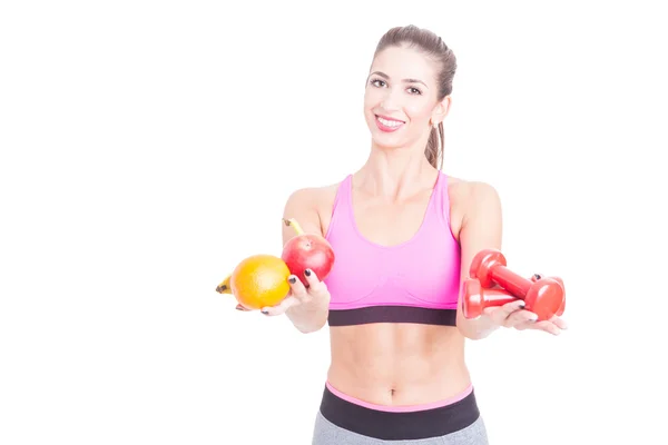 Adatta ragazza che tiene frutta e pesi come equilibrio — Foto Stock