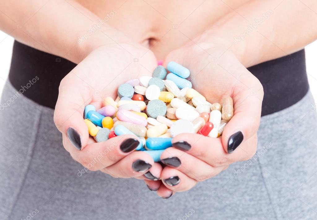 Close-up of girl hands holding pills or supplements