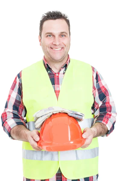 Vrolijke mannelijke constructeur die helm en handschoenen vasthoudt — Stockfoto