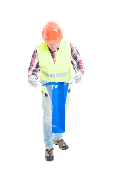 Curious builder looking inside shopping bag — Stock Photo, Image