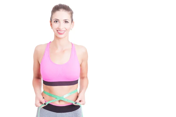 Chica en el gimnasio sosteniendo centímetro alrededor de la cintura — Foto de Stock