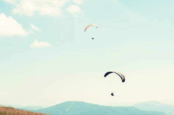 Two paragliders in sky with hills in background — Stock Photo, Image