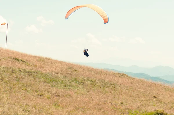 Paraglider taking off from green hill — Stock Photo, Image
