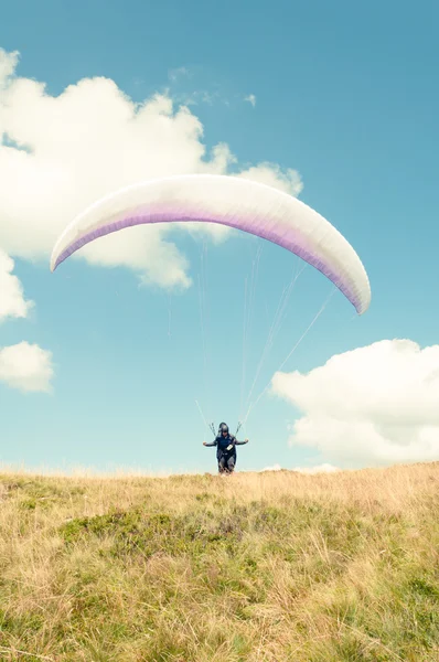 从绿色的山丘起飞的滑翔伞 — 图库照片