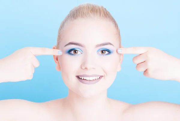 Porträtt av flicka pekar på blå ögonskugga smink — Stockfoto