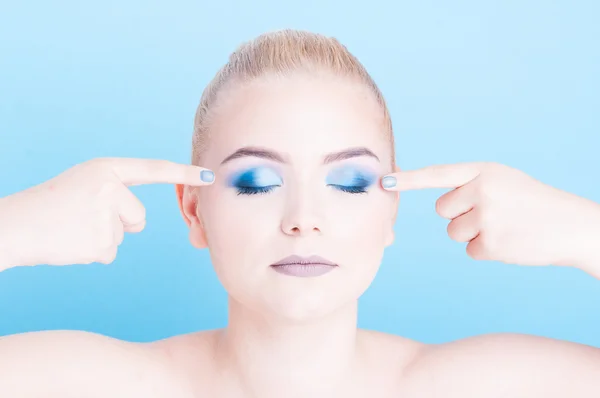 Retrato de menina apontando na maquiagem sombra azul — Fotografia de Stock