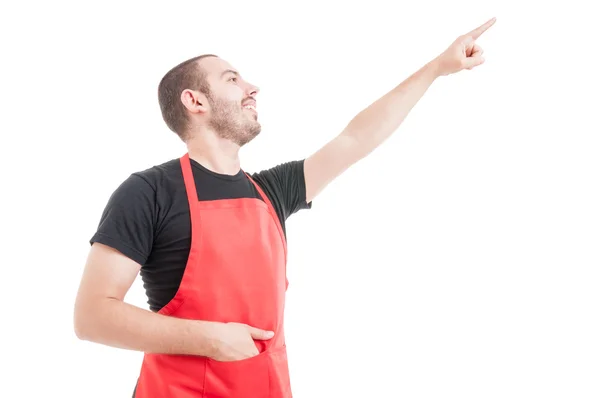 Freundliche Supermarkt-Mitarbeiterin zeigt nach oben — Stockfoto