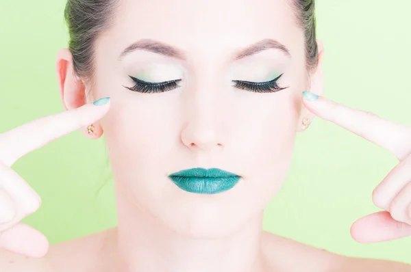 Mujer señalando sus ojos usando maquillaje glamoroso profesional — Foto de Stock