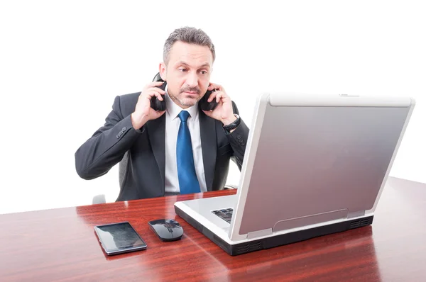 Jonge manager met koptelefoon leest iets op laptop — Stockfoto