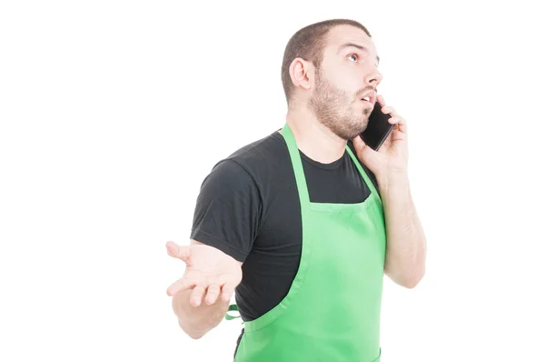Market employee explaining something on phone — Stock Photo, Image