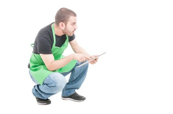 Supermarket young employee searching something holding tablet — Stock Photo, Image