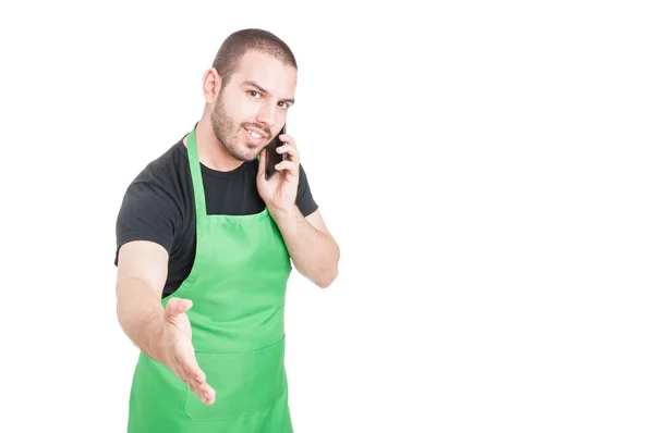 Junge Supermarkt-Mitarbeiterin macht Handschlag-Geste am Telefon — Stockfoto