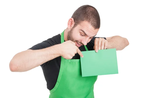 Funcionário do mercado apontando papelão verde e sorrindo — Fotografia de Stock