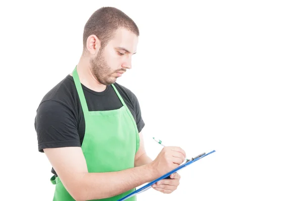 Hipermercado vendedor escribiendo algo en portapapeles — Foto de Stock