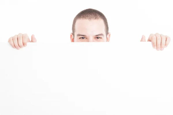 Supermarket seller hiding from big advertising board Stock Picture