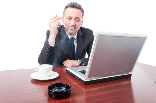 Homem vestindo terno e fumando no escritório — Fotografia de Stock