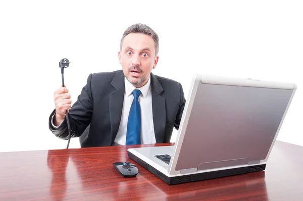 Uomo d'affari che fissa e mostra filo elettrico in ufficio — Foto Stock