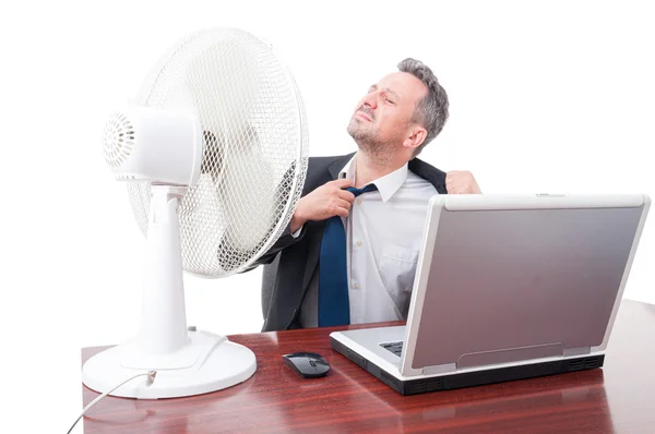 Hombre de negocios tirando de la corbata delante del ventilador —  Fotos de Stock