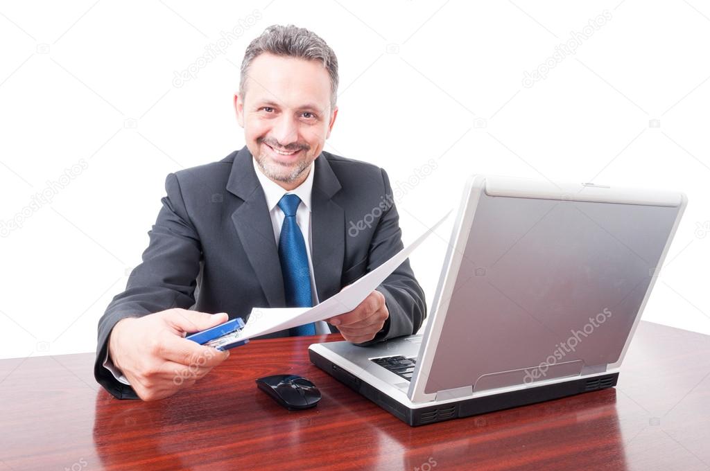 Man wearing suit at office holding stapler and documents