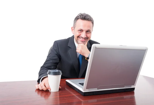 Человек в офисе улыбается держа чашку кофе — стоковое фото
