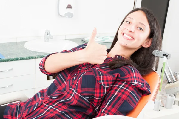 Pretty woman showing thumb up in dentist chair — Stock Photo, Image