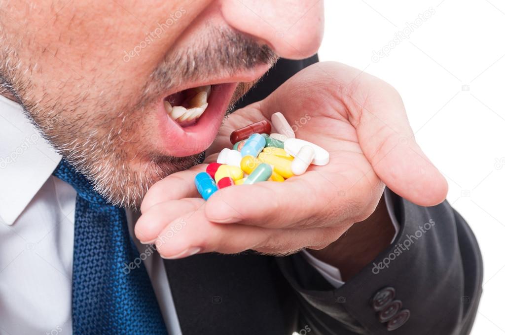 Close-up of man in suit having lot of pills