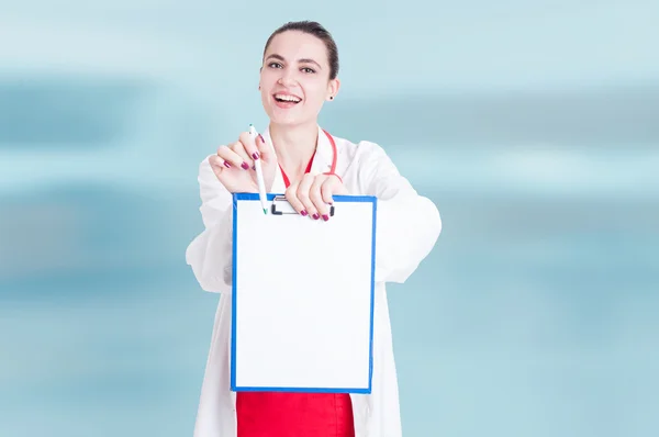 Friendly female doctor offering blank clipboard