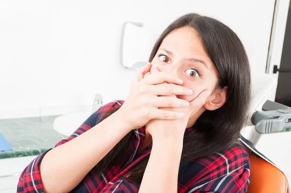 Dame sitzt im Zahnarztstuhl und bedeckt ihren Mund — Stockfoto