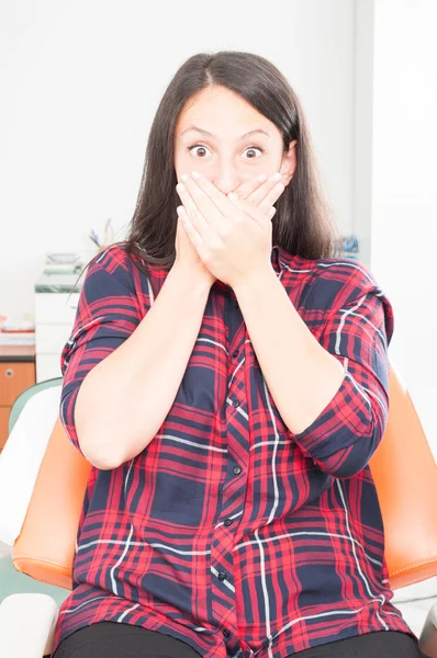Jonge dame die betrekking hebben op mond op tandarts stoel — Stockfoto