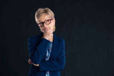 Mavi jaket ve gözlük takan yaşlı bir sekreterin portresi.