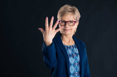 Eski sekreter, siyah arka planda mavi ceket giyen beş numarayı gösteriyor.