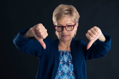 Üzgün eski sekreter koyu arka planda çifte hoşnutsuzluk işareti gösteriyor.