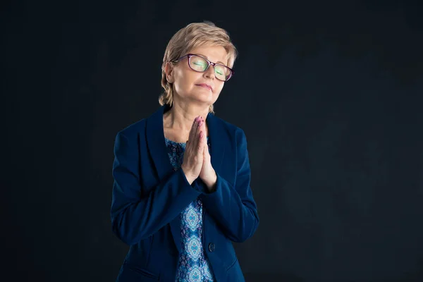 Starsza Bizneswoman Modli Się Niebieskiej Kurtce Ciemnym Tle Obraz Stockowy