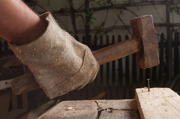 Hammer schlägt Nagel ins Holz — Stockfoto