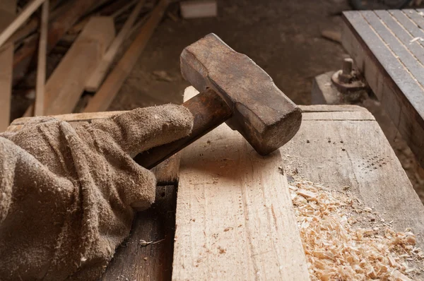 Hand legt einen Hammer auf einen Holztisch — Stockfoto