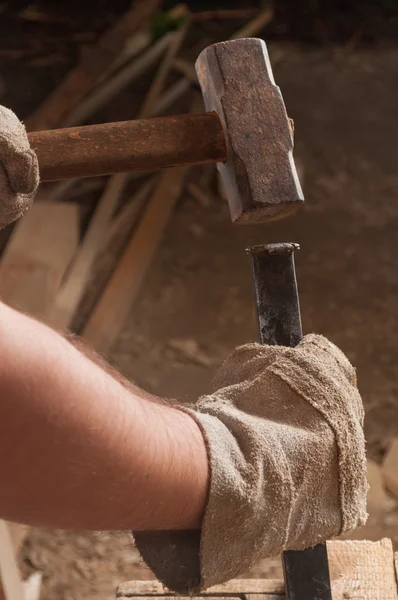 Arbeiter schlägt mit Hammer auf Meißel ein — Stockfoto
