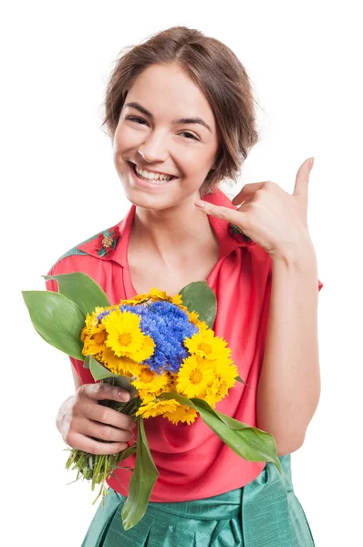 Frau macht Anruf Geste mit der Hand, während sie Blumen hält — Stockfoto