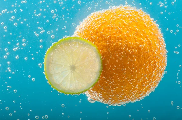 Orange and lime slice in bubbles water — Stock Photo, Image