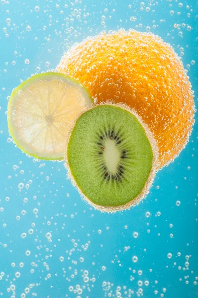 Orange, kiwi and lime in water with bubbles — Stock Photo, Image