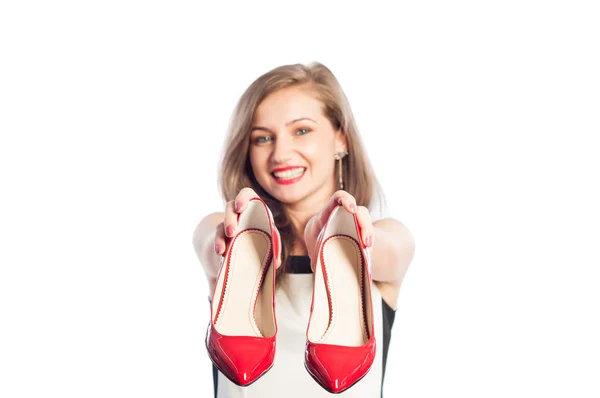 Femme souriante tenant des chaussures rouges — Photo