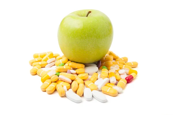 Green apple on pills — Stock Photo, Image