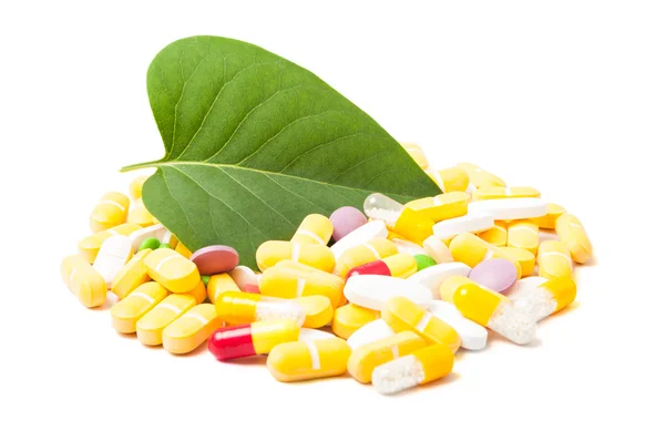 Green leaf and bunch of pills — Stock Photo, Image