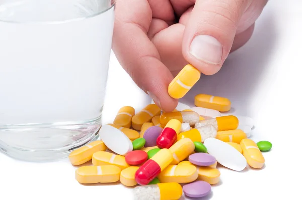 Bunch of pills and a glass of water — Stock Photo, Image