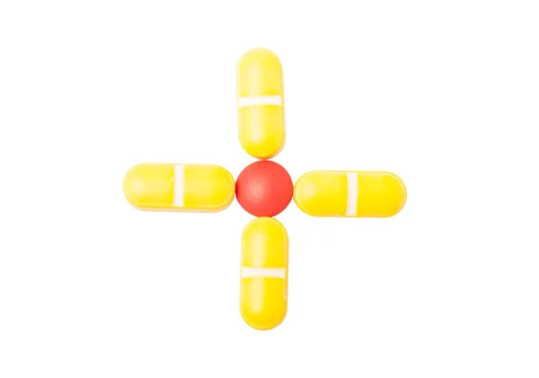 Cross or plus sign made with pills — Stock Photo, Image