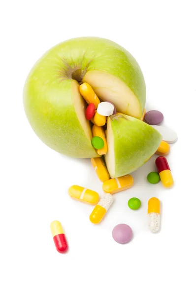 Luonnollinen vihreä omena ja erilaisia pillereitä — kuvapankkivalokuva