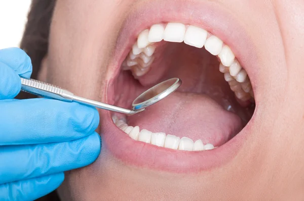 Dentista inspecionando dentes usando espelho — Fotografia de Stock